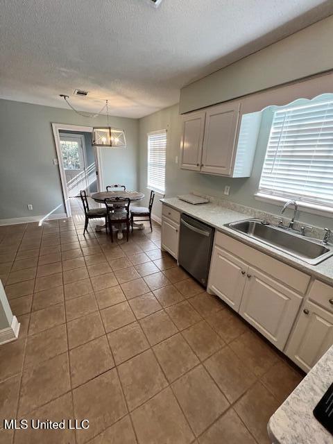 kitchen featuring pendant lighting, sink, white cabinetry, and dishwasher