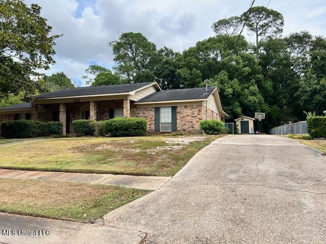 ranch-style house with a storage shed and a front lawn