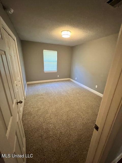 unfurnished bedroom featuring light colored carpet and a textured ceiling