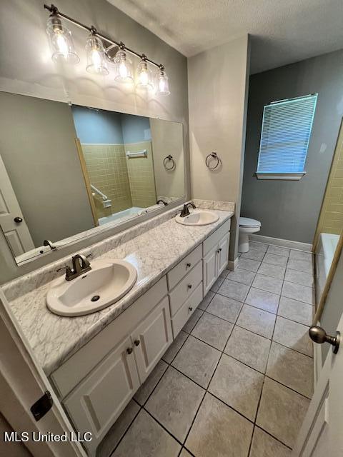 bathroom with vanity, a shower, a textured ceiling, tile patterned floors, and toilet