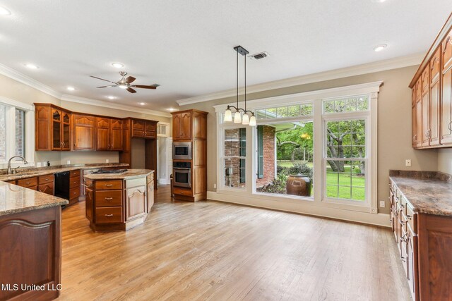 421 Starling Dr, Slidell, LA 70461 - kitchen featuring light wood-style floors, pendant lighting, light stone counters, appliances with stainless steel finishes, and brown cabinetry