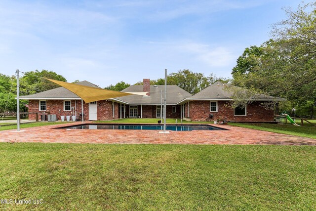 421 Starling Dr, Slidell, LA 70461 - rear view of property with central AC, an outdoor pool, brick siding, and a yard