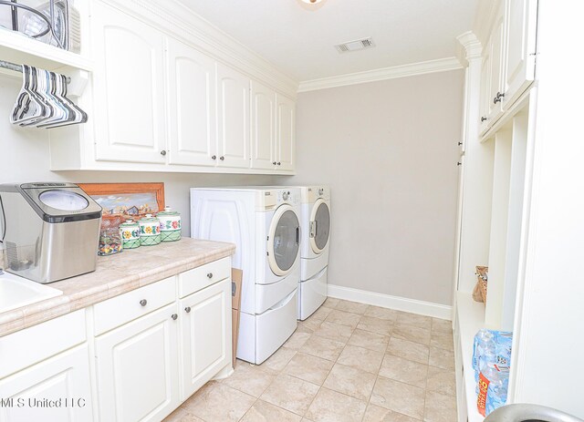 109 Elizabeth Dr, Brandon, MS 39042 - washroom with washer and dryer, cabinet space, crown molding, baseboards, and light tile patterned floors