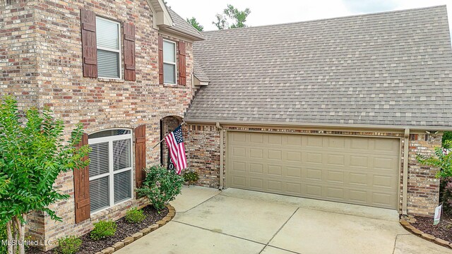 109 Elizabeth Dr, Brandon, MS 39042 - view of front facade with a shingled roof, brick siding, driveway, and a garage