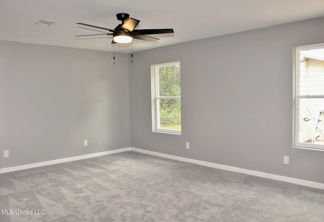 carpeted spare room featuring ceiling fan