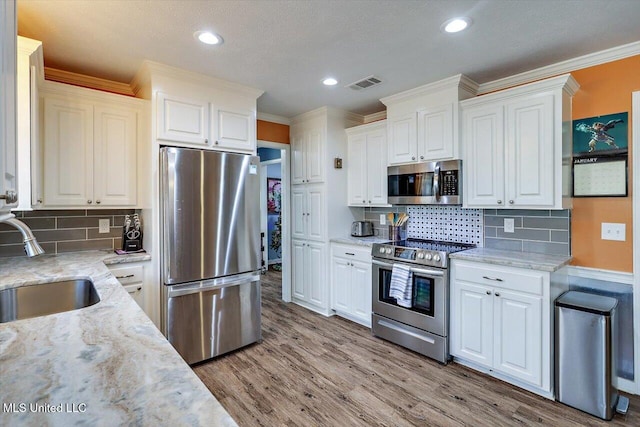 kitchen with white cabinetry, sink, light hardwood / wood-style flooring, and stainless steel appliances