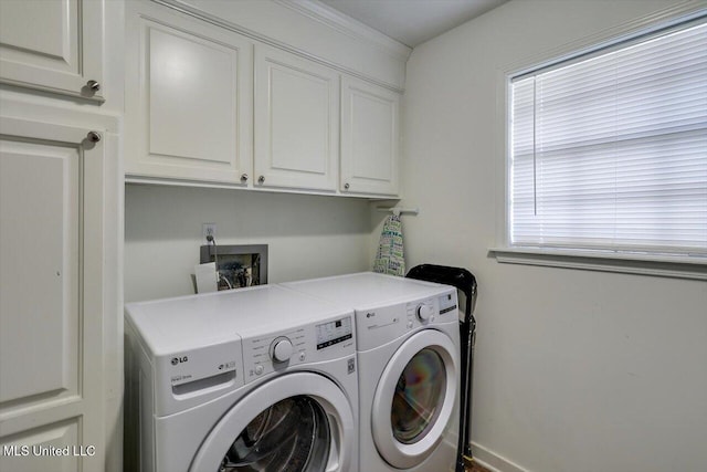 clothes washing area featuring washer and clothes dryer and cabinets