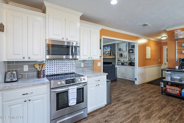 kitchen featuring appliances with stainless steel finishes, dark hardwood / wood-style floors, white cabinets, ornamental molding, and light stone countertops