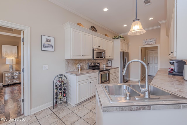 127 Palin Dr, Madison, MS 39110 - kitchen featuring stainless steel appliances, ornamental molding, tasteful backsplash, recessed lighting, and white cabinetry