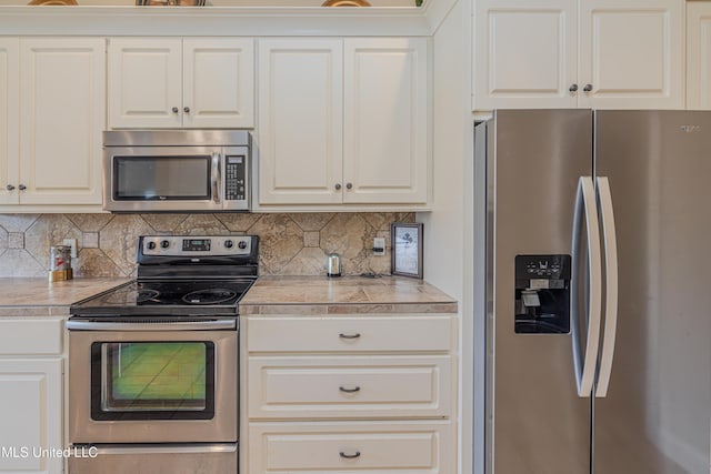 127 Palin Dr, Madison, MS 39110 - kitchen with appliances with stainless steel finishes, decorative backsplash, tile countertops, and white cabinetry