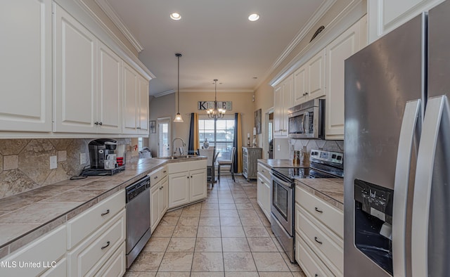 127 Palin Dr, Madison, MS 39110 - kitchen featuring appliances with stainless steel finishes, a chandelier, tile counters, decorative light fixtures, and white cabinets