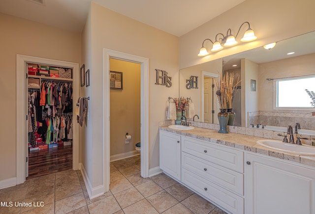 127 Palin Dr, Madison, MS 39110 - bathroom featuring a garden tub, double vanity, tile patterned floors, and a walk in closet