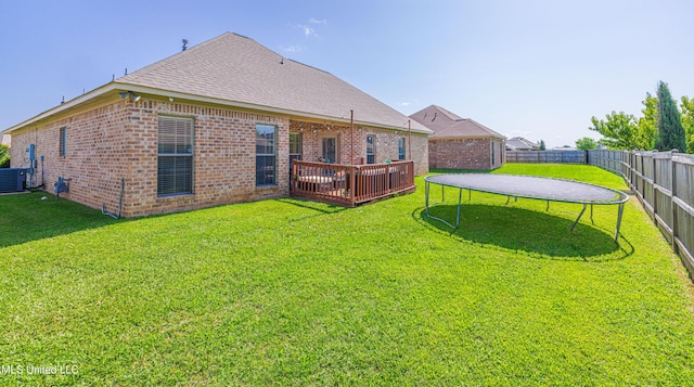 127 Palin Dr, Madison, MS 39110 - back of property with a trampoline, a fenced backyard, brick siding, and a shingled roof