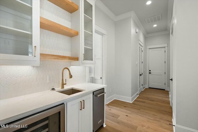 kitchen featuring wine cooler, visible vents, backsplash, white cabinetry, and a sink