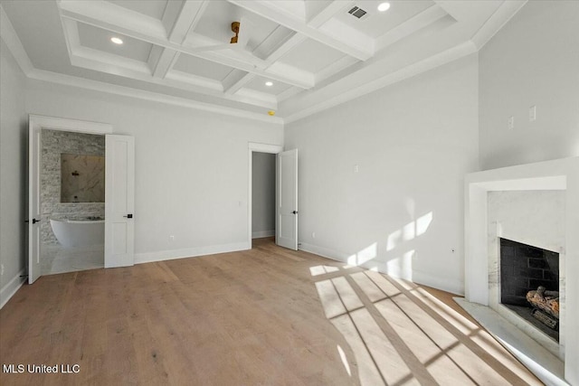 unfurnished living room featuring visible vents, coffered ceiling, light wood-style flooring, beam ceiling, and a high end fireplace