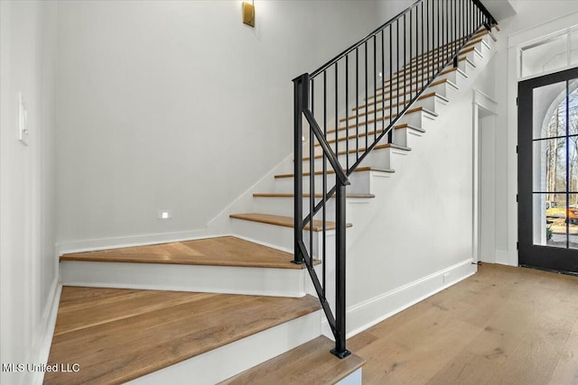 entryway featuring stairs, wood finished floors, and baseboards