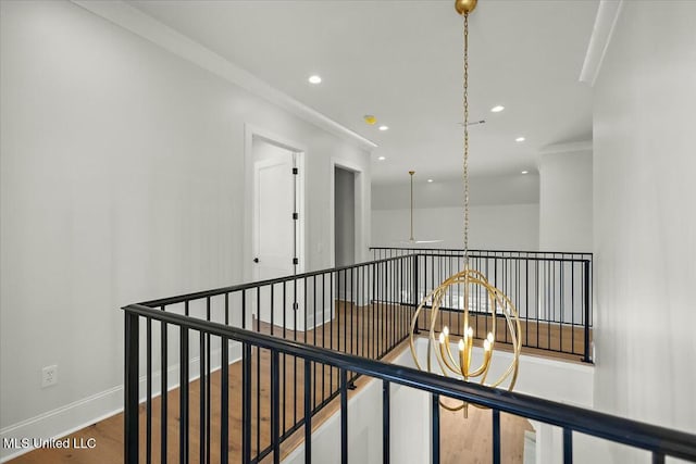 hallway with baseboards, wood finished floors, an upstairs landing, a chandelier, and recessed lighting