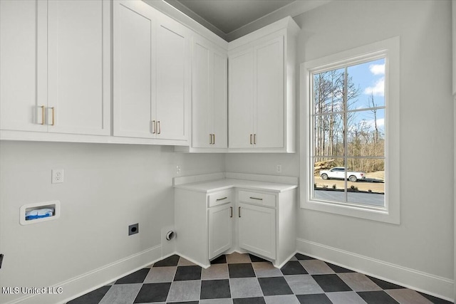 laundry room with dark floors, cabinet space, electric dryer hookup, and baseboards