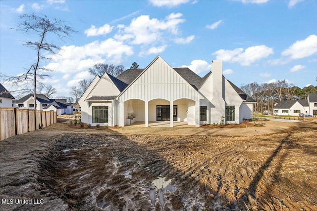 view of front of house with a chimney and fence