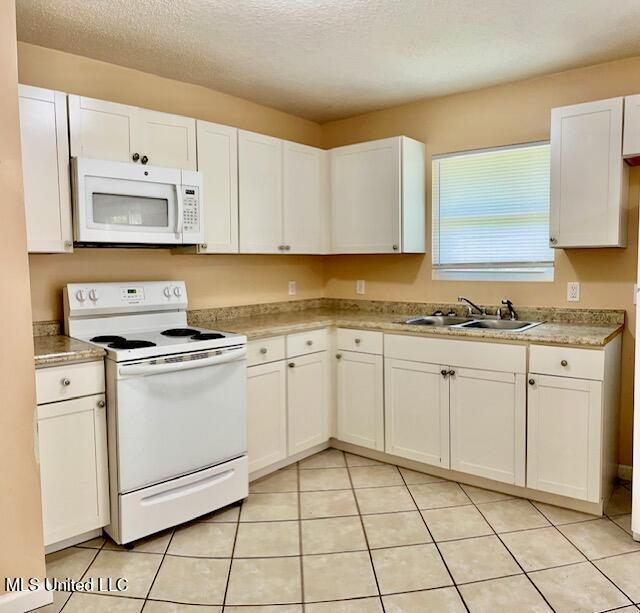 2614 George St, Gulfport, MS 39503 - kitchen featuring white appliances, a sink, white cabinets, light countertops, and a textured ceiling