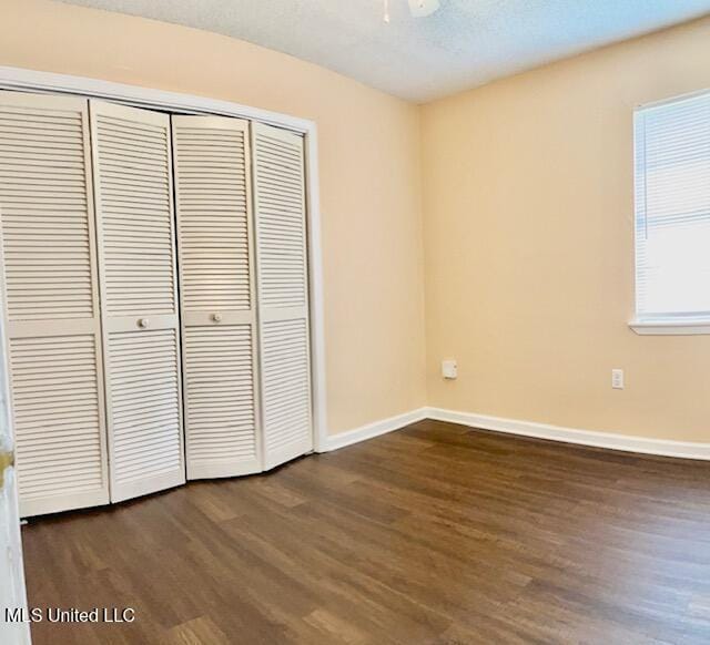 2614 George St, Gulfport, MS 39503 - unfurnished bedroom with dark wood-type flooring, a closet, and baseboards