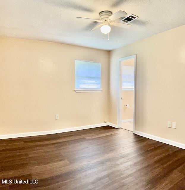 2614 George St, Gulfport, MS 39503 - empty room featuring a ceiling fan, dark wood-style flooring, baseboards, and a textured ceiling