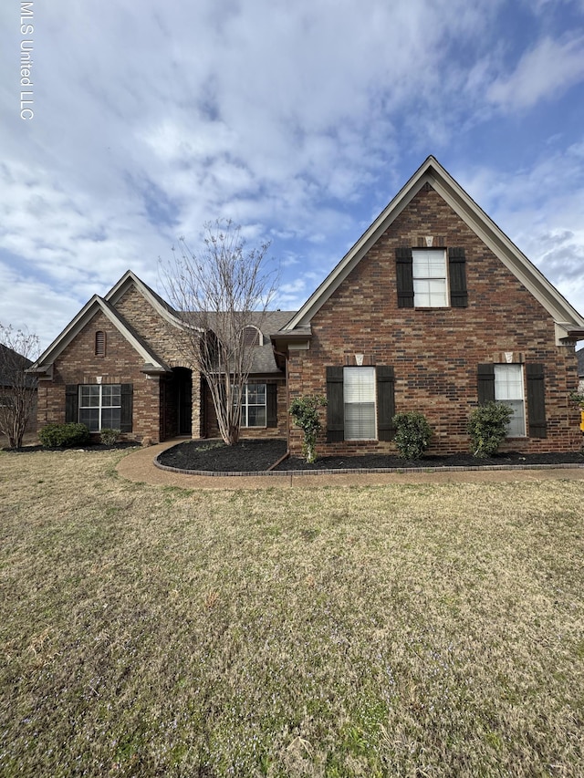 traditional-style house with a front lawn and brick siding