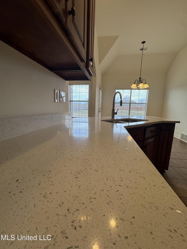 kitchen featuring dark brown cabinetry, a healthy amount of sunlight, visible vents, and a sink