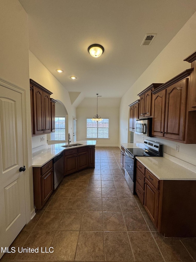 kitchen with visible vents, a peninsula, a sink, light countertops, and appliances with stainless steel finishes