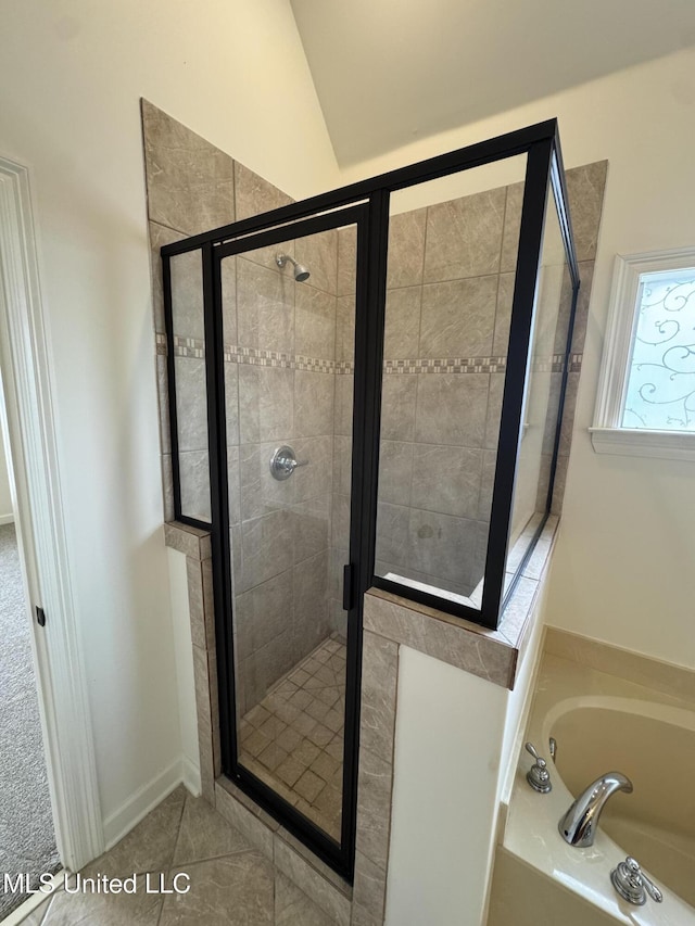 bathroom with a bath, tile patterned floors, a stall shower, and vaulted ceiling