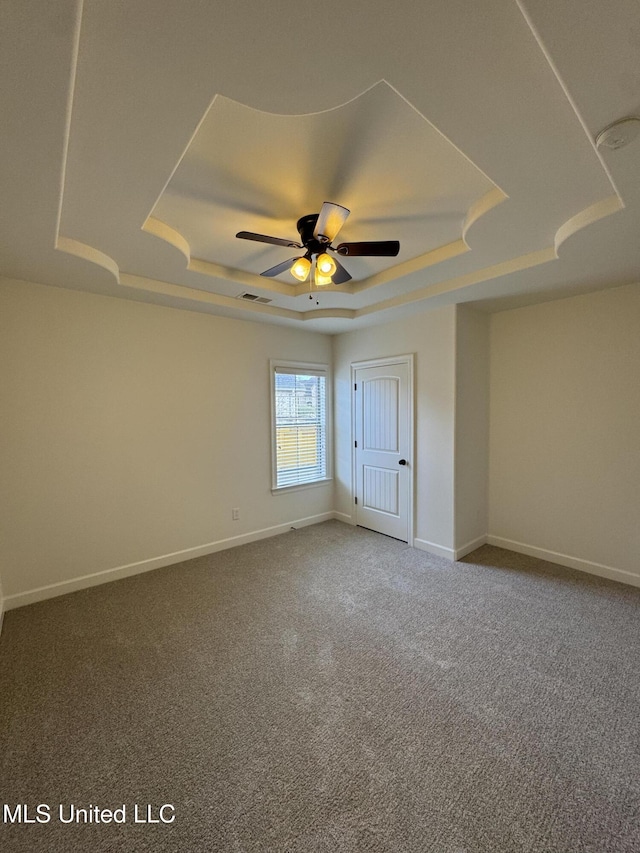 unfurnished bedroom with carpet, a raised ceiling, visible vents, and baseboards