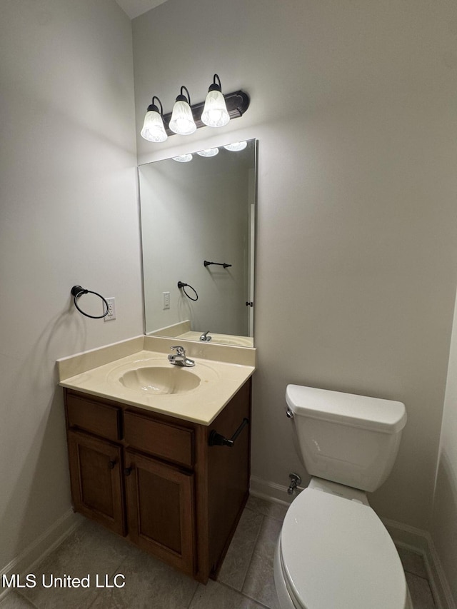 half bath featuring vanity, toilet, and baseboards