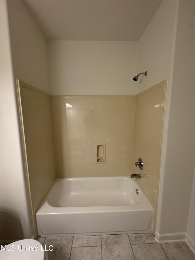 bathroom featuring tile patterned floors, toilet, and shower / bathtub combination