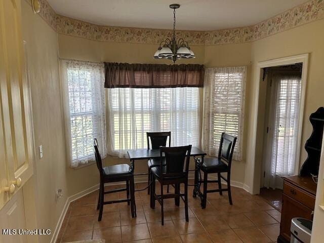 tiled dining room with an inviting chandelier