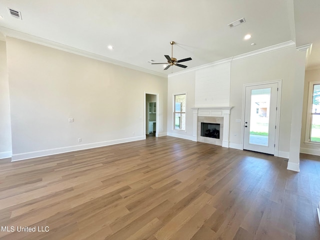 unfurnished living room with light hardwood / wood-style flooring, ceiling fan, a fireplace, and crown molding