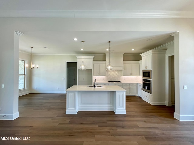 kitchen featuring sink, stainless steel appliances, white cabinets, dark hardwood / wood-style floors, and a kitchen island with sink