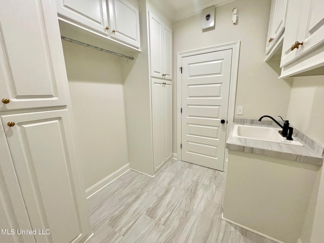 mudroom featuring sink and light wood-type flooring