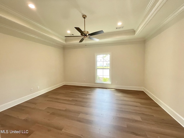 unfurnished room featuring ornamental molding, dark wood-type flooring, a tray ceiling, and ceiling fan