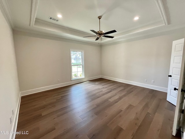 unfurnished room with dark wood-type flooring, crown molding, and a raised ceiling