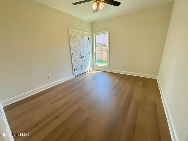 spare room with crown molding, wood-type flooring, and ceiling fan