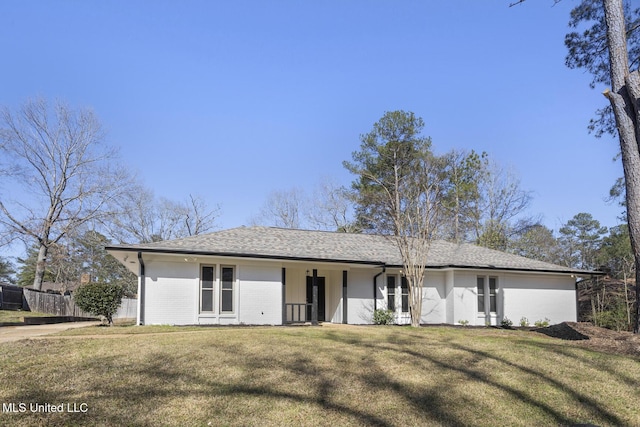 ranch-style house featuring brick siding, a shingled roof, a front yard, and fence