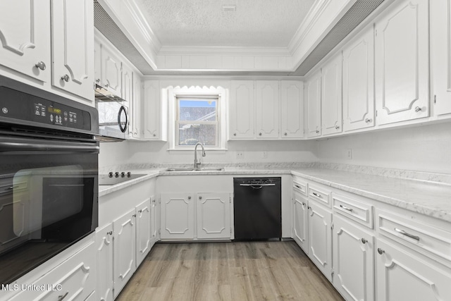 kitchen with a sink, black appliances, ornamental molding, and white cabinets