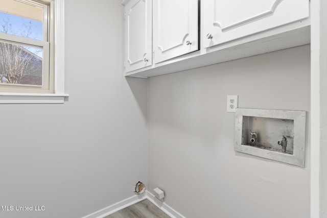 laundry area with cabinet space, wood finished floors, baseboards, and washer hookup