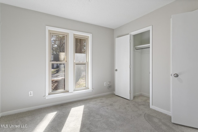 unfurnished bedroom featuring a closet, a textured ceiling, baseboards, and carpet