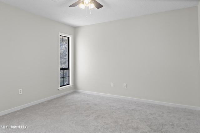 carpeted empty room with a wealth of natural light, baseboards, a textured ceiling, and ceiling fan