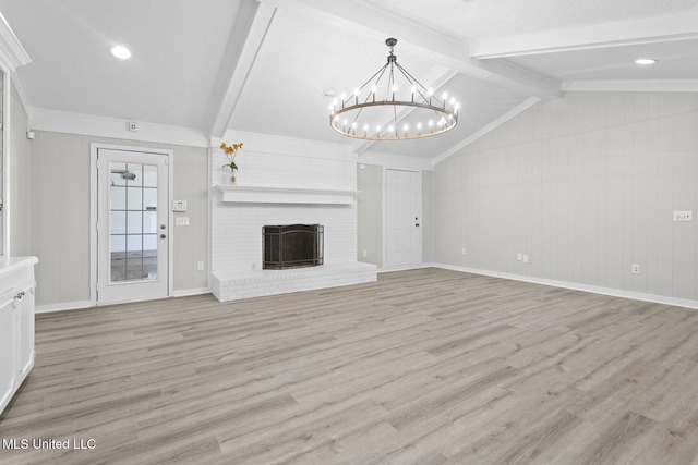 unfurnished living room with a notable chandelier, light wood-style floors, baseboards, a brick fireplace, and vaulted ceiling with beams