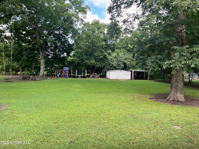409 Coleman St, Como, MS 38619 - view of green lawn featuring a playground, a carport, and an outdoor structure