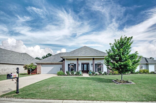 view of front of house featuring a front lawn, french doors, brick siding, an attached garage, and driveway
