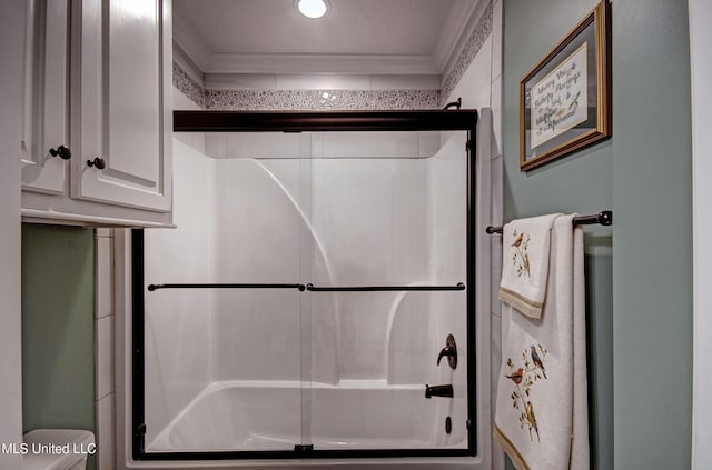bathroom featuring an enclosed shower, toilet, and ornamental molding