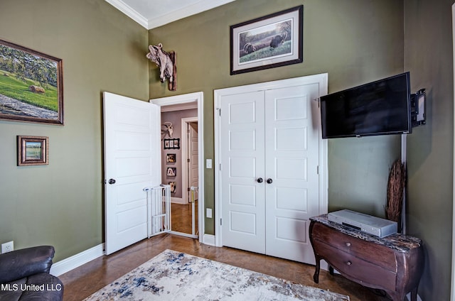 bedroom featuring baseboards, ornamental molding, and a closet